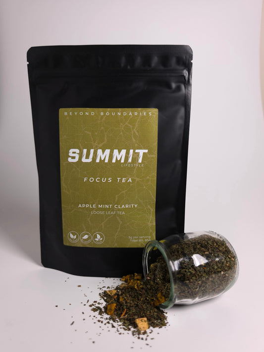 A black stand-up pouch of Summit Lifestyle Focus Tea with a gold label, shown next to a clear glass jar tipped over with loose leaf tea spilled out on a white surface against a light gray background.
